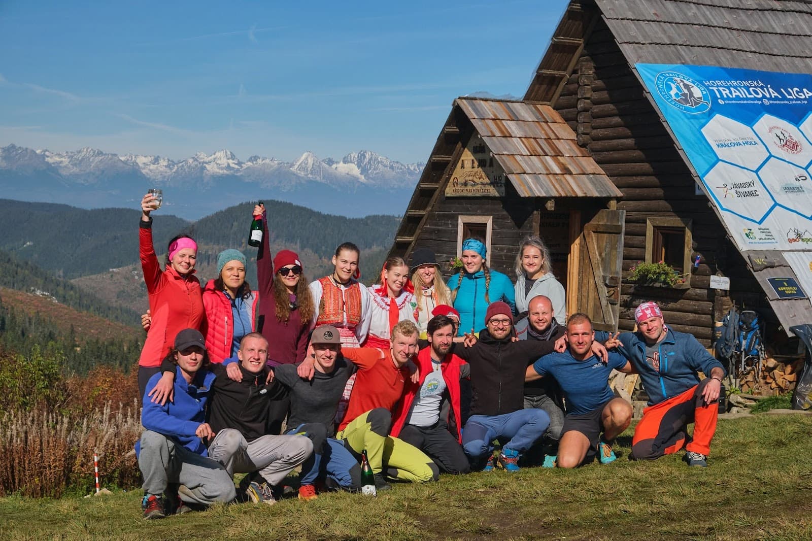 Skupina turistov pred útulňou za slnečného dňa