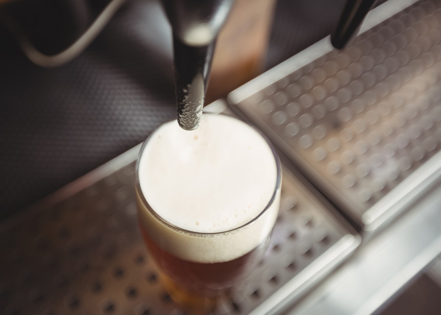 Close-up of beer glass with froth in a bar